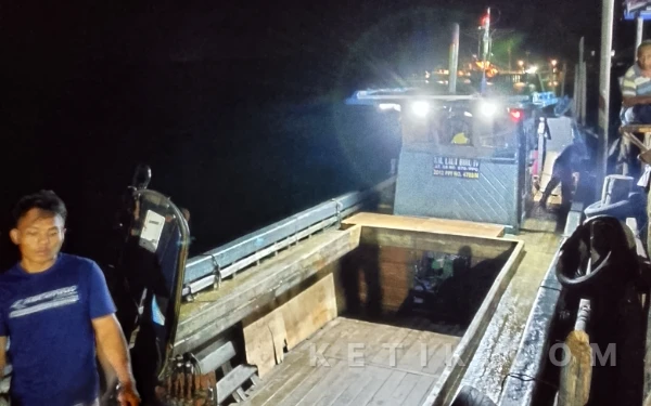 Foto Suasana bongkar muat malam hari di Pelabuhan Akau, Jembatan Enam Barelang. Sebuah kapal kayu bersandar dengan bak muatan terbuka, sementara aktivitas pemindahan barang berlangsung di dermaga tanpa pengawasan terbuka yang terlihat di lokasi. (Poto Istimewa)