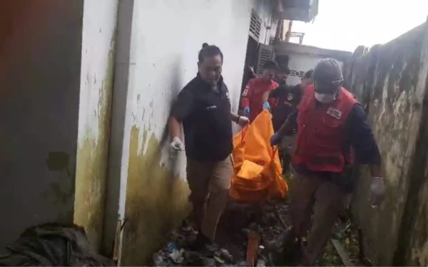 Foto Anggota PMI Kota Palembang bersama Tim Inafis Polrestabes Palembang saat mengevakuasi mayat yang ditemukan di sebuah rumah kosong di Jalan M Isa, Lorong Srikandi, Kelurahan 8 Ilir, Kecamatan Ilir Timur III, Palembang, Sabtu 10 Januari 2026 (Foto : Yola/Ketik.Com)