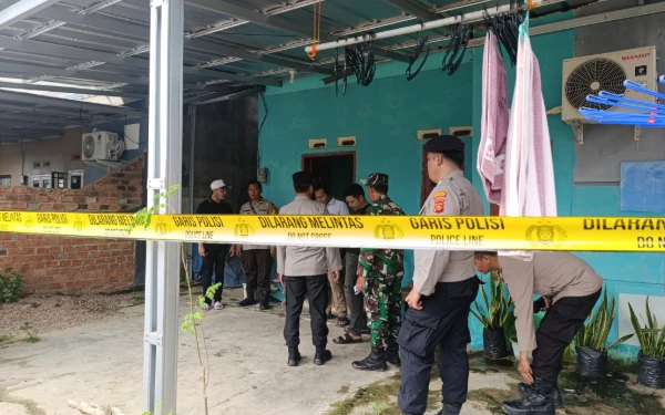 Foto Pihak kepolisian saat memasang garis polisi di rumah pembunuhan IRT di  Komplek Karya Mandiri 5, Lebak Murni, Sako, Kota Palembang, Rabu 21 Januari 2025 (Foto : Yola/Ketik.Com)