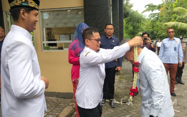 Foto Kepala SMAN 1 Kebomas Komari menyambut Menko Pangan Zulkifli Hasan dengan pengalungan  bunga. (Foto : Sutejo, Rc/Ketik.com)