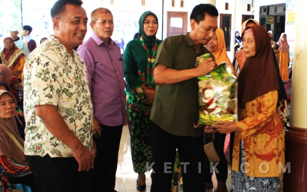 Foto Kepala Dinas Sosial Sidoarjo Martha W. Kusuma menyerahkan bantuan beras premium kepada warga disaksikan oleh Camat Candi Yuni Rismawati dan Kepala Desa Kalipecabean Arif Ansori. (Foto: Fathur Rozi/Ketik.com)