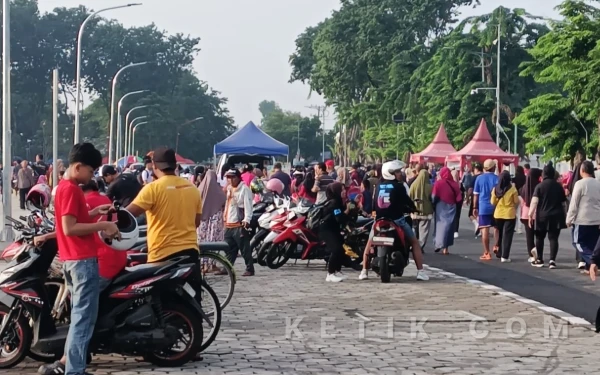 Foto Seorang jukir tidak berseragam (bertopi) membantu menata kendaraan pengunjung Alun-Alun Jayandaru saat parkir saat berlangsung car free day pada Minggu (1 Februari 2026). (Foto: Fathur Rozi/Ketik.com)