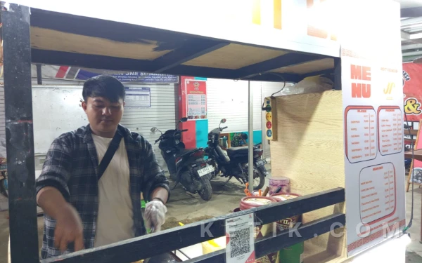 Foto Saka memanggang pesanan pembeli di lapak roti bakar Jaya Rasa di Jalur Lintas Selatan (JLS) Sirnoboyo, Pacitan, Sabtu, 7 Februari 2026 malam. (Foto: Al Ahmadi/Ketik.com)