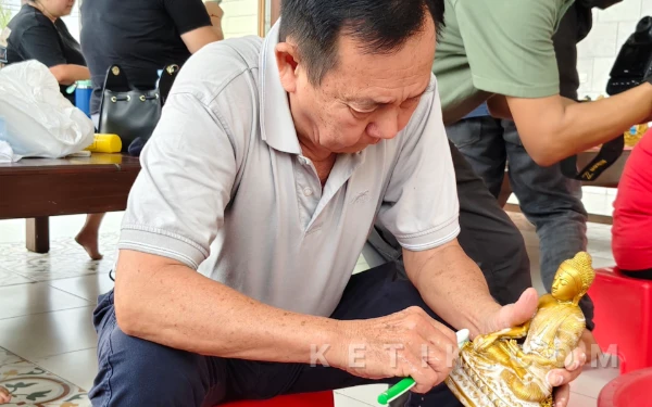 Foto Pengurus Vihara Buddayana Putat Gede Surabaya, membersihkan rupang kecil menggunakan sabun dan sikat. (Foto: Fitra/Ketik.com)