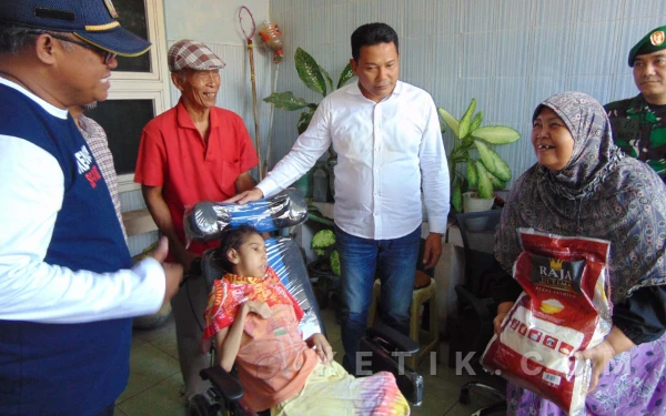 Foto Bupati Subandi memberikan bantuan kursi roda untuk Bianca Beatrix Pearl , warga Desa Sidorejo, Krian.  (Foto: Fathur Roziq/Ketik.com)
