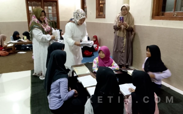 Foto Wabup Malang Hj Lathifah Shohib ketika membagikan jilbab kepada santri usai salat tarawih di masjid At Thohiriyah. (Foto: Binar Gumilang/ketika.com)