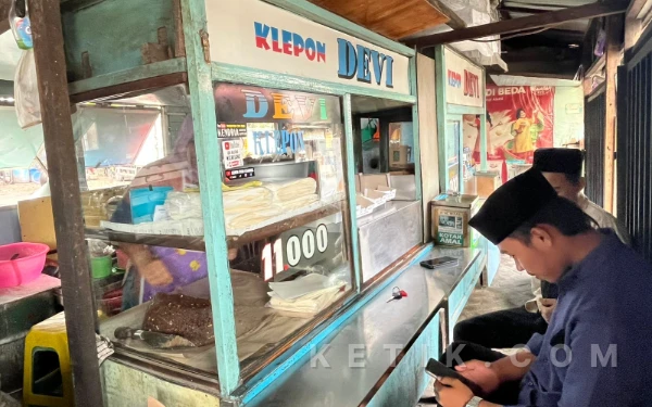 Foto Seorang pembeli menunggu pesanan di depan etalase gerai Klepon dan Gempo Devi yang terletak di Jalan Raya Alun-Alun Menganti, Gresik, pada11 Februari 2026.
(Foto: Ismy Dahlia Handayani / ketik.com)