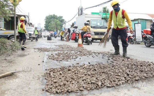 Foto Pekerja proyek memperbaiki jalan rusak di wilayah Sukodono, Sidoarjo pada Selasa (24 Februari 2026). (Foto: Sigit/Kominfo)