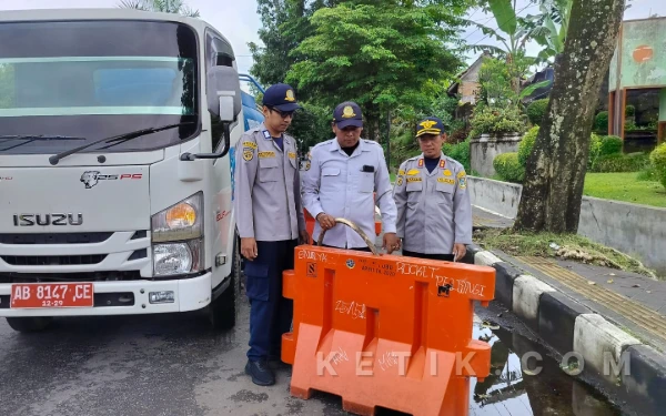 Foto Kepala UPTD Pengelolaan Perparkiran Sleman, Wahyu Slamet (kanan), memantau langsung proses pengisian air ke dalam water barrier di Simpang 3 Jalan Eks PJKA, Beran, Kamis, 26 Februari 2026. Pengisian air ini melibatkan armada dari Dinas Lingkungan Hidup (DLH) Sleman agar pembatas jalan menjadi kokoh dan tidak mudah digeser. (Foto: Azis/Ketik.com)