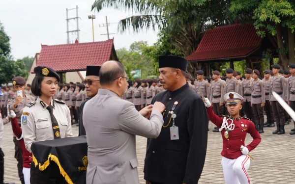 Foto Kadisdik Jatim Aries Agung Paewai (kiri) menyematkan tanda jabatan kepada I Ketut Renen yang dipercaya sebagai Plt. Kepala SMAN 2 Taruna Bhayangkara di sela Upacara Sertijab di Banyuwangi, Kamis, 26 Februari 2026. (Foto: Humas Disdik Jatim)