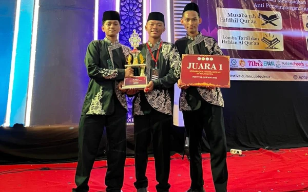 Foto Tampak Fawaidz Al-Khudzaifi bersama kedua rekanya Nabhan (kanan) dan Rahmad (kiri) tengah membawa sejumlah penghargaan setelah meraih juara 1 lomba MFQ tingkat nasional dalam Festival Qur’ani UINSA 2025. (Foto: Dok. Pribadi)