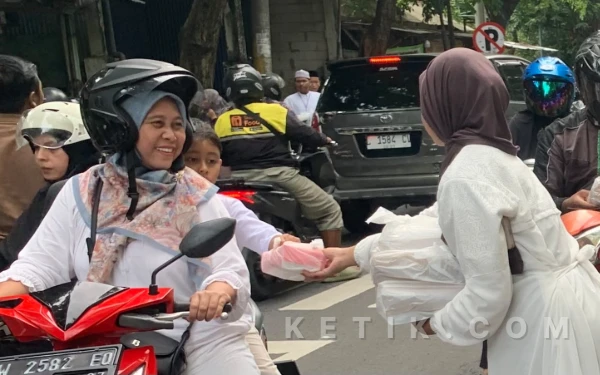 Foto Salah Satu Siswi SMPN 1 Gresik Bagikan Takjil Ke Pengendara Jalan (Foto : Daniel Andayawan/Ketik.com)
