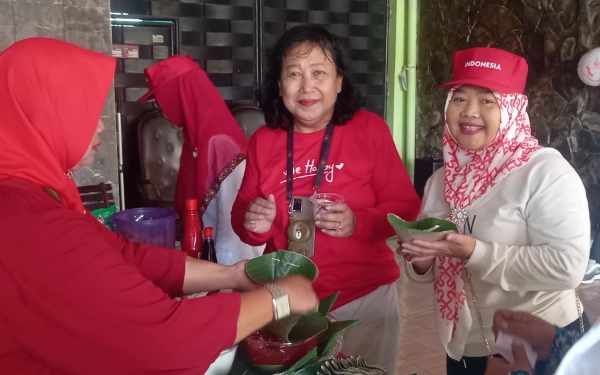 Foto Usai jalan sehat, Ketua RT Lory (kiri)  dan Ibu Tri menikmati bubur Madura. (Foto: Sumarno/Ketik.com)
