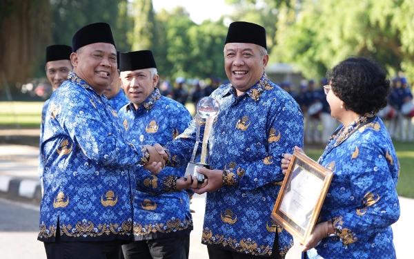 Foto Bupati Sleman Harda Kiswaya (kiri) saat memberikan penghargaan pada Kepala Bappeda Sleman Dwi Anta Sudibya. Bappeda masuk kategori perangkat daerah Pemkab Sleman dengan penilaian kinerja terbaik kedua tahun 2024. (Foto: Prokopim Sleman/Ketik)