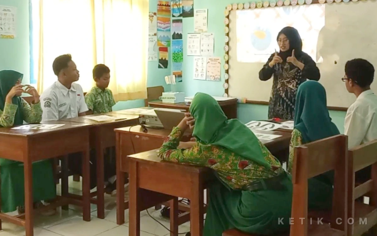 Foto Caption foto: Guru SLB YKK Pacitan, Yasi Rahajeng Anindyajati saat memberikan instruksi dengan bahasa isyarat kepada siswa tunarungu dalam kegiatan pembelajaran di kelas.