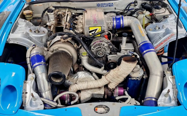 Thumbnail Mobil ikonik Mazda RX-7 dengan mesin rotary yang telah dimodifikasi menjadi Quad Rotor. Mazda RX-7 sebagai mobil standard harian adalah mobil yang cukup langka dan dicari oleh banyak penggemar fanatik mobil rotary di seluruh dunia. Dengan mesin rotary yang unik dan desain body yang elegan, mobil ini merupakan salah satu ikon mobil Jepang di era 80an hingga 2000an. (Foto: MGPA)