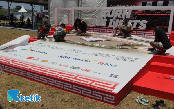 Thumbnail Para pekerja menyelesaikan giant map area pesta rakyat Mandalika. (Foto: Rahmat Rifadin/Ketik)