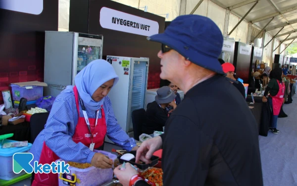 Thumbnail Tenant UMKM melayani seorang pembeli. (Foto: Rahmat Rifadin/Ketik)