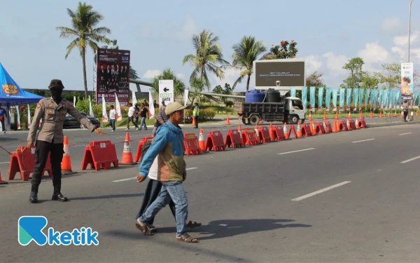 Thumbnail Petugas siaga membantu masyarakat menyeberangkan di depan sirkuit Mandalika. (Foto: Rahmat Rifadin/Ketik)