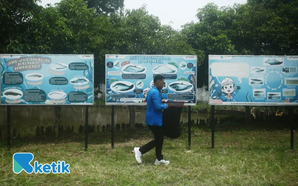 Thumbnail Siswa Universitas PGRI Palembang Fakultas Perikanan dan Kelautan melintas di papan keterangan jenis dan status konservasi ikan belida di Indonesia yang ada di Pusat Riset dan Konservasi Ikan Belida di Kampus C Universitas PGRI Palembang Jalan. Sakti Wiratama RT 8 RW 2 Kelurahan Srimulya, Kecamatan. Sematang Borang, Palembang, Sumatera Selatan, Sabtu 18 Oktober 2025. (Foto:Wahyu Rahmanto/ketik.com)