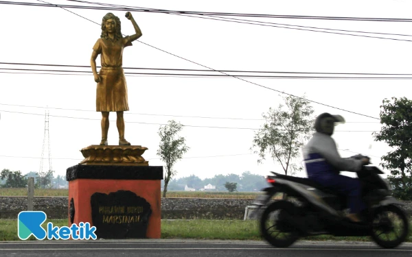 Thumbnail Patung Marsinah berdiri tegak di kampung halamannya yakni samping Jalan Raya Baron, tepatnya di Desa Nglundo, Sukomoro, Nganjuk, Jawa Timur yang merupakan jalur antarprovinsi Surabaya-Yogyakarta, 10 November 2025. (Foto: Rahmat Rifadin/Ketik.com)