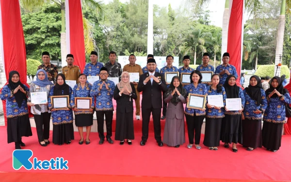 Thumbnail Bupati Bassam Kasuba bersama Kepala Dinas Kesehatan Asia Hasyim, Direktur RSUD Halsel dr. Titin Adriyanti beserta 15 Nakes Teladan Penanggung jawab Program terbaik tahun 2025 Berpose Bersama usai Upacara HKN di Halaman Kantor Bupati Senin 17 November 2025 (Foto: Mursal/Ketik.com)