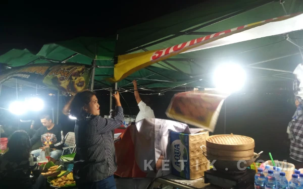 Thumbnail Berita - Diterjang Angin Kencang, Pedagang Pasar Senggol Rampal Bertahan Pegangi Tenda