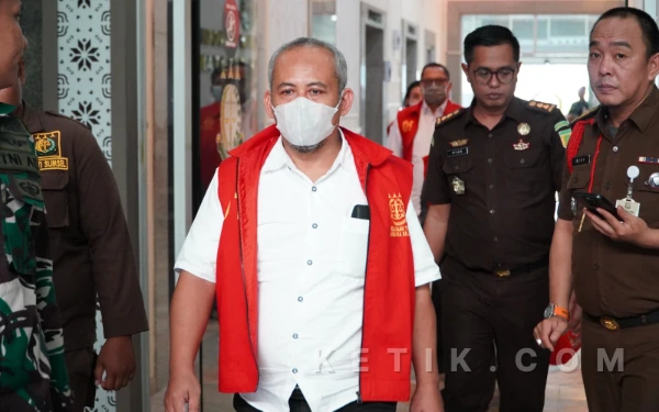 Foto Petugas mengawal salah satu tersangka kasus dugaan korupsi fasilitas kredit Bank BRI kepada PT BSS dan PT SAL saat proses Tahap II di Kejaksaan Tinggi Sumatera Selatan, Senin 9 Maret 2026. (Foto: M Nanda/Ketik.com)