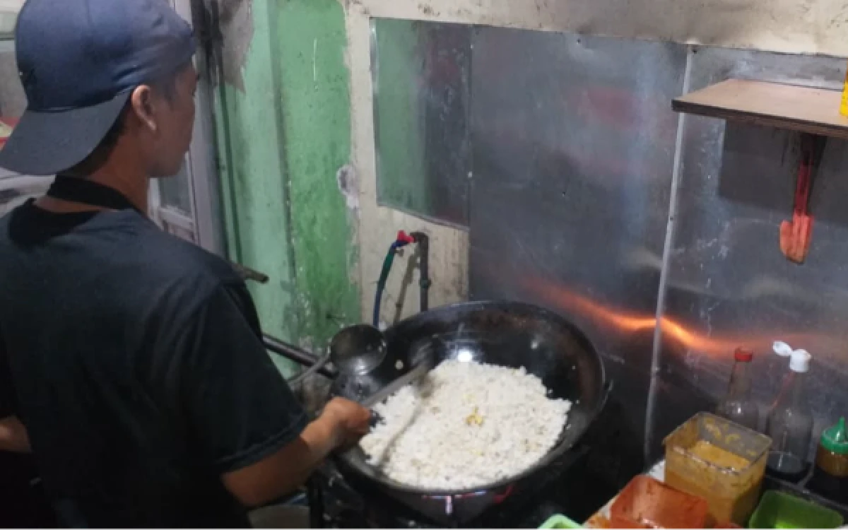 Foto Mas Bowo sedang memasak pesanan pelanggan. tanggal 18 April 2026 di Jl. Ketintang Baru 2A no. 6 Ketintang, Surabaya. (foto: Muhammad Fajar Hasan/ketik.com)