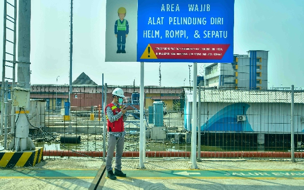 Thumbnail Seorang petugas kemanan dengan APD lengkap sedang berkoordinasi memantau kondisi di Pelabuhan Samudera 2 Subholding PT Pelindo Multi Terminal (SPMT) Branch Tanjung Emas Semarang, Rabu (22/5/2024). (Foto: Achmad Fazeri/Ketik.co.id)