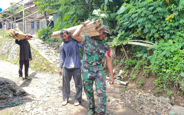Thumbnail Berita - Percepat Pembangunan MCK, Satgas TMMD Kodim Situbondo dan Warga Gercep Panggul Kayu di Medan Ekstrem