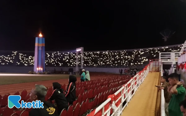 Thumbnail Para penonton menyalakan lampu ponsel saat penutupan Porprov IX Jatim di Stadion Kanjuruhan Kabupaten Malang. (Foto: Binar Gumilang/Ketik)