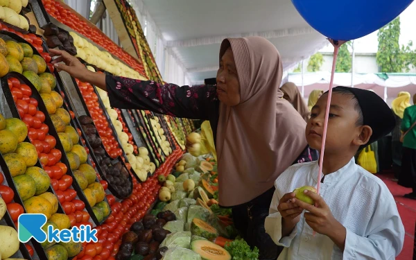 Thumbnail Anak yatim saat mengambil buah hias maulid nabi. (Foto: Karimatul Maslahah/Ketik)