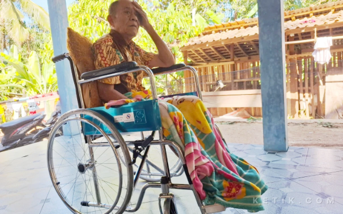 Foto Mbah Kaderi duduk di kursi roda bantuan dari KSB Pacitan usai penyerahan bantuan di kediamannya di Desa Kalikuning, Kecamatan Tulakan, Sabtu, 25 Juli 2026.