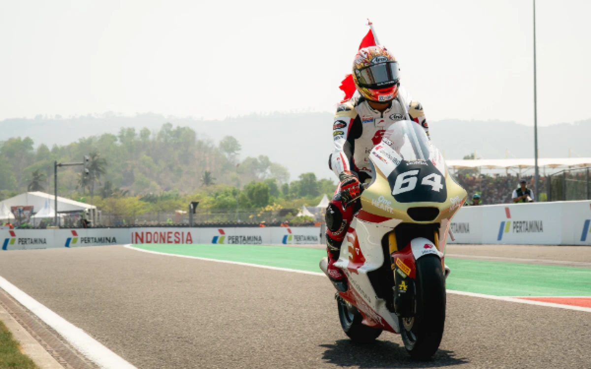 Foto Mario Suryo Aji pembalap Moto2 Indonesia mengibarkan bendera Merah Putih keliling Sirkuit Mandalika usai tampil di Moto2 GP Indonesia, 11 Oktober 2026. (Foto: Honda Team Asia)