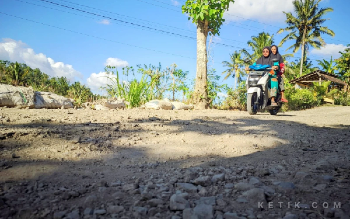 Foto Pengendara sepeda motor melintas dengan hati-hati di ruas Jalan Pringkuku-Pelem yang rusak.