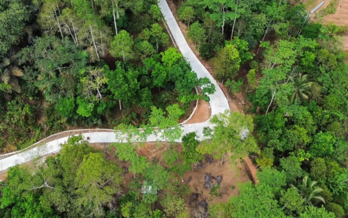 Foto Jalan beton membentang di antara kawasan perbukitan dan permukiman. Kualitas konstruksi jalan dipengaruhi mutu material, pelaksanaan pengecoran, dan perawatan beton. (Foto: PT Rizki Bangun Beton).