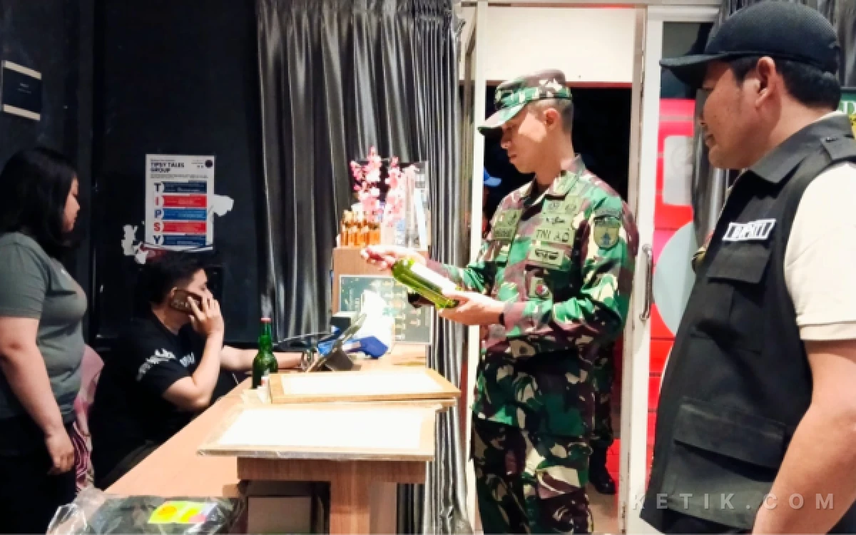 Foto Dandim 0816/Sidoarjo Letkol Abraham Prihadi bertanya tentang minuman dan izin penjualan miras kepada penjaga salah satu toko penjual miras di kawasan Perumahan KNV Sidoarjo pada Jumat malam (31 Juli 2026). (Foto: Fathur Roziq/Ketik.com)