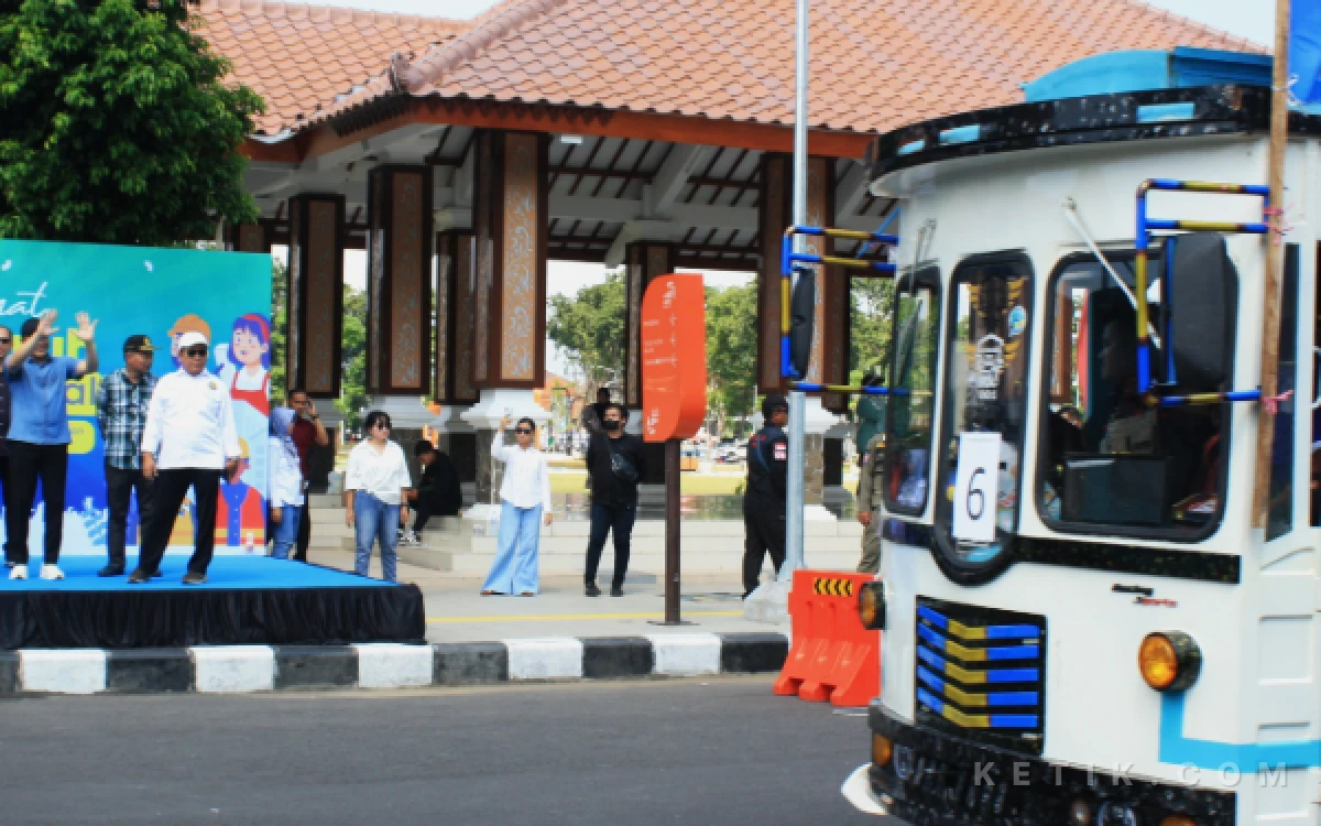 Foto Bupati Subandi melambaikan tangan saat rombongan pekerja berangkat menuju Kota Surabaya untuk merayakan peringatan May Day pada Jumat 1 Mei 2026. (Foto: Fathur Roziq/Ketik.com)