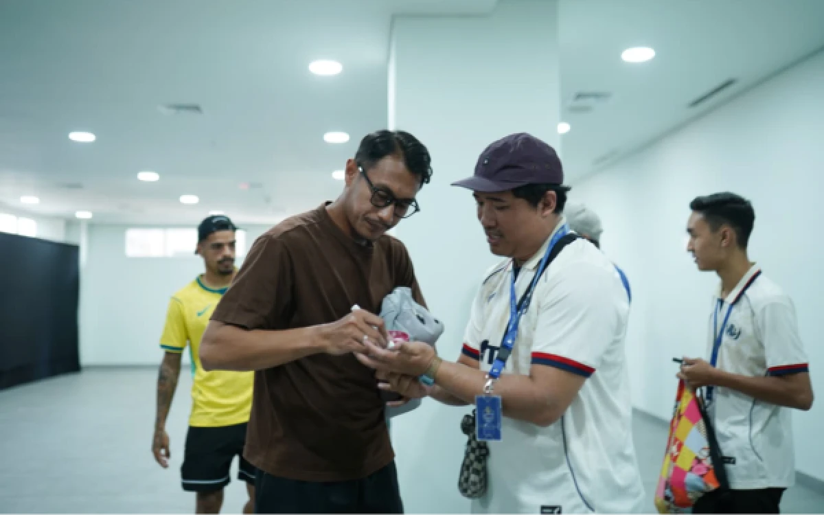 Foto Penggawa Arema FC, Hansamu Yama, memberikan tanda tangan kepada salah seorang peserta program Inside The Lion Home. (Foto: Media Officer Arema FC)