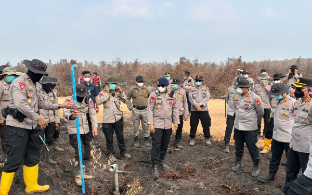 Foto Karo Ops Polda Sumsel Kombes Pol Muhammad Anis Prasetio Santoso, S.I.K., M.Si dan Personel operasi Aman Nuaa II Polda Sumsel saat memperagakan langsung simulasi penggunaan cairan khusus X-Fire di Desa Teluk Limau, Kecamatan Gelumbang, Kabupaten Muara Enim, Senin 14 September 2026, (Foto : Yola/Ketik.com)