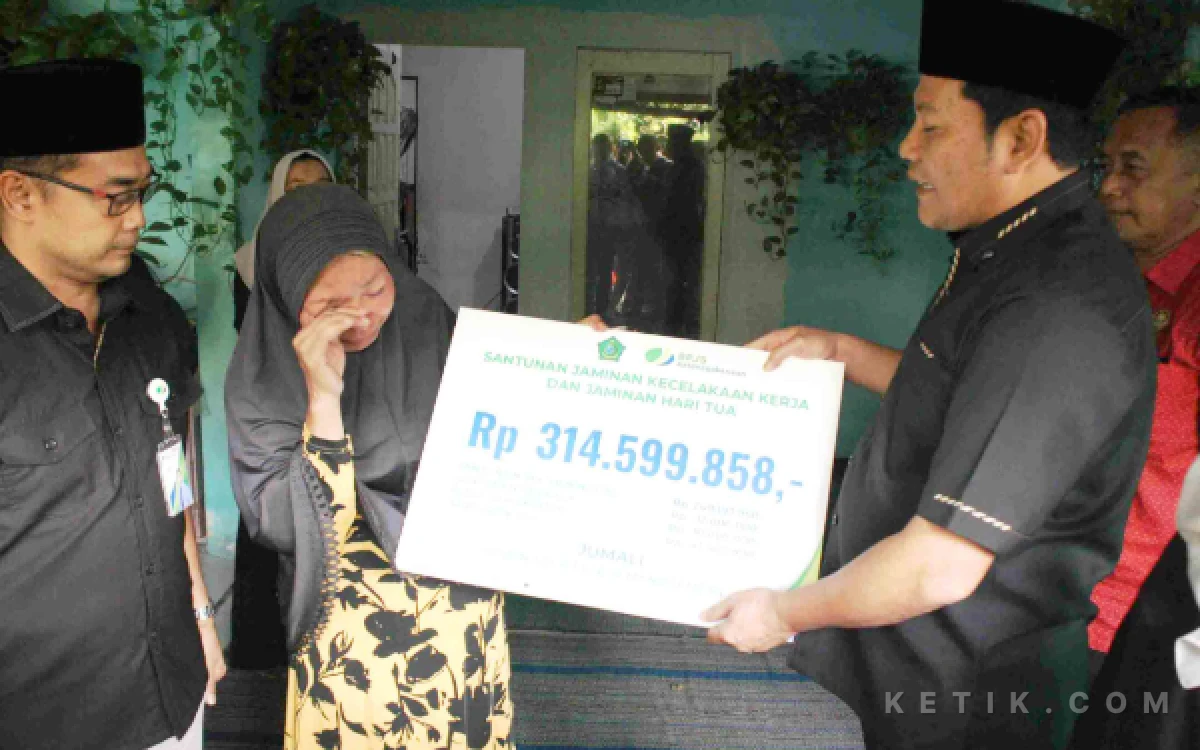 Foto Bupati Subandi menyerahkan santunan kecelakaan dan jaminan hari tua kepada istri Jumali, Sri Utami, didampingi oleh Kepala Cabang BPJS Ketenagakerjaan Sidoarjo Arie Fianto Sofyan pada Jumat (8 Mei 2026). (Foto: Fathur Roziq/Ketik.com)