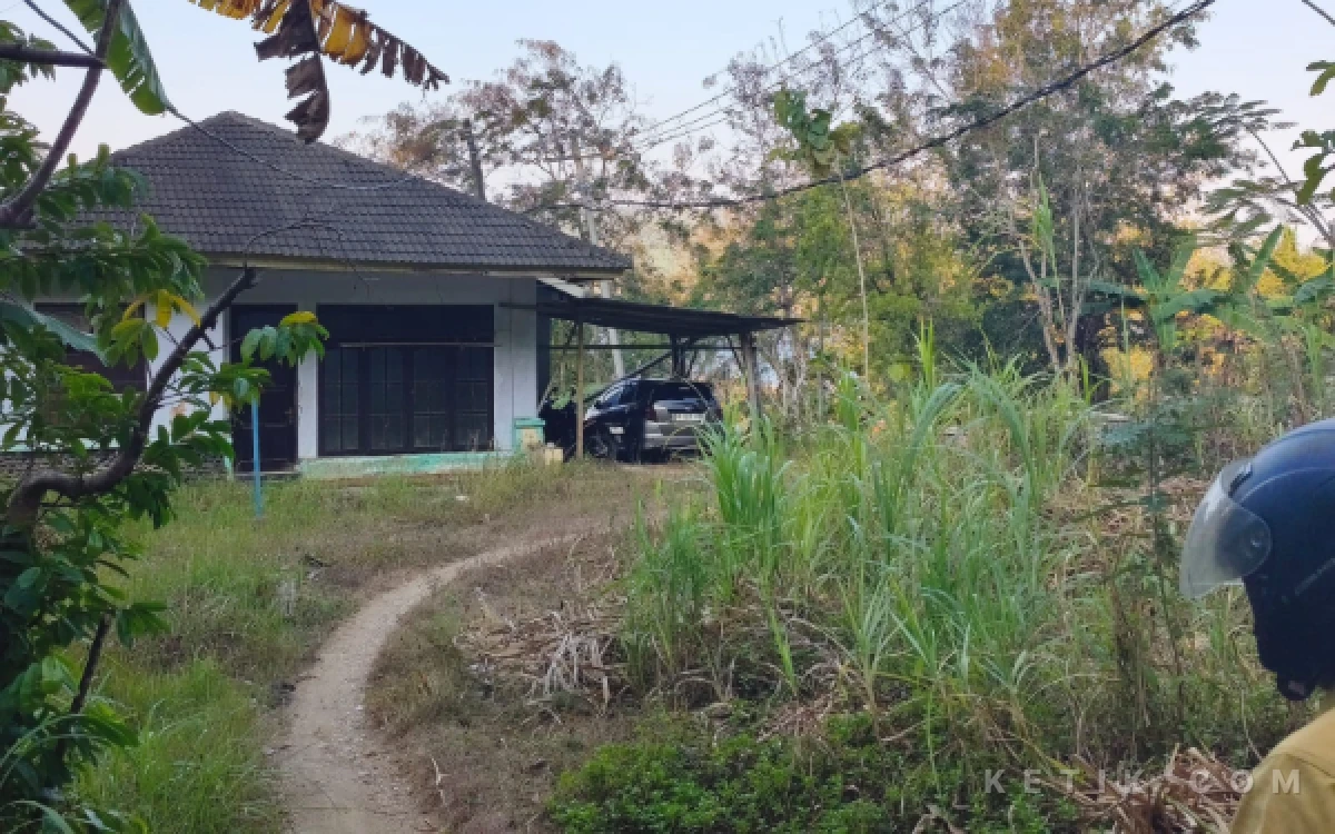 Foto Bangunan yang disebut sebagai bekas mes di kawasan Tamperan, Kelurahan Sidoharjo, Pacitan, tampak tidak terawat dan dikelilingi rerumputan serta tanaman liar. Akses menuju bangunan berupa jalan setapak, sementara sebagian halaman digunakan sebagai tempat parkir kendaraan.