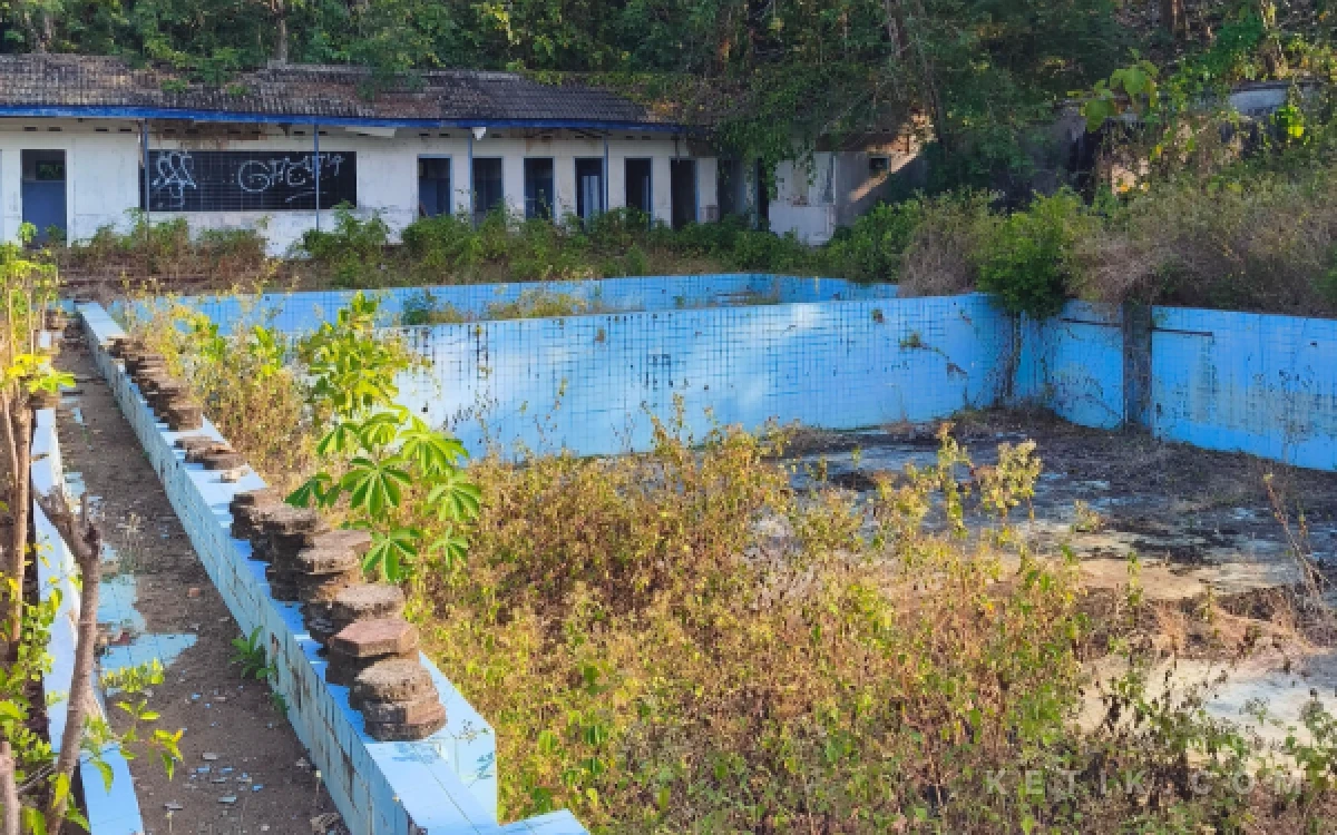 Foto Kondisi kolam renang tua di kawasan Tamperan, Kelurahan Sidoharjo, Pacitan, yang disebut telah terbengkalai sejak sekitar dekade 2000-an. Dinding kolam masih terlihat, tetapi dipenuhi tanaman liar dan bagian fasilitasnya mulai rusak dimakan usia.