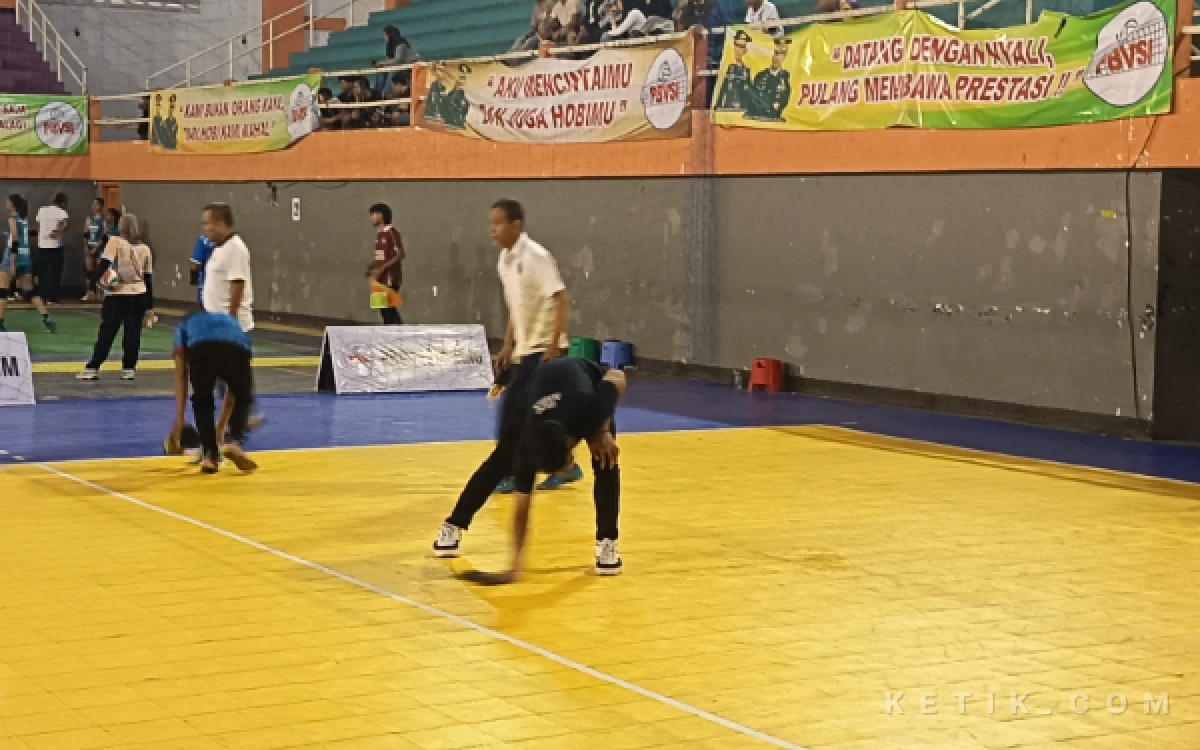 Foto Panitia kerja keras berusaha mengeringkan lapangan di sela-sela laga Kejurprov Bola Voli Antar Klub U19 Se-Jawa Timur 2026 di GOR Merdeka Jombang, Selasa 27 Oktober 2026. (Foto: Rifat/Ketik.com)