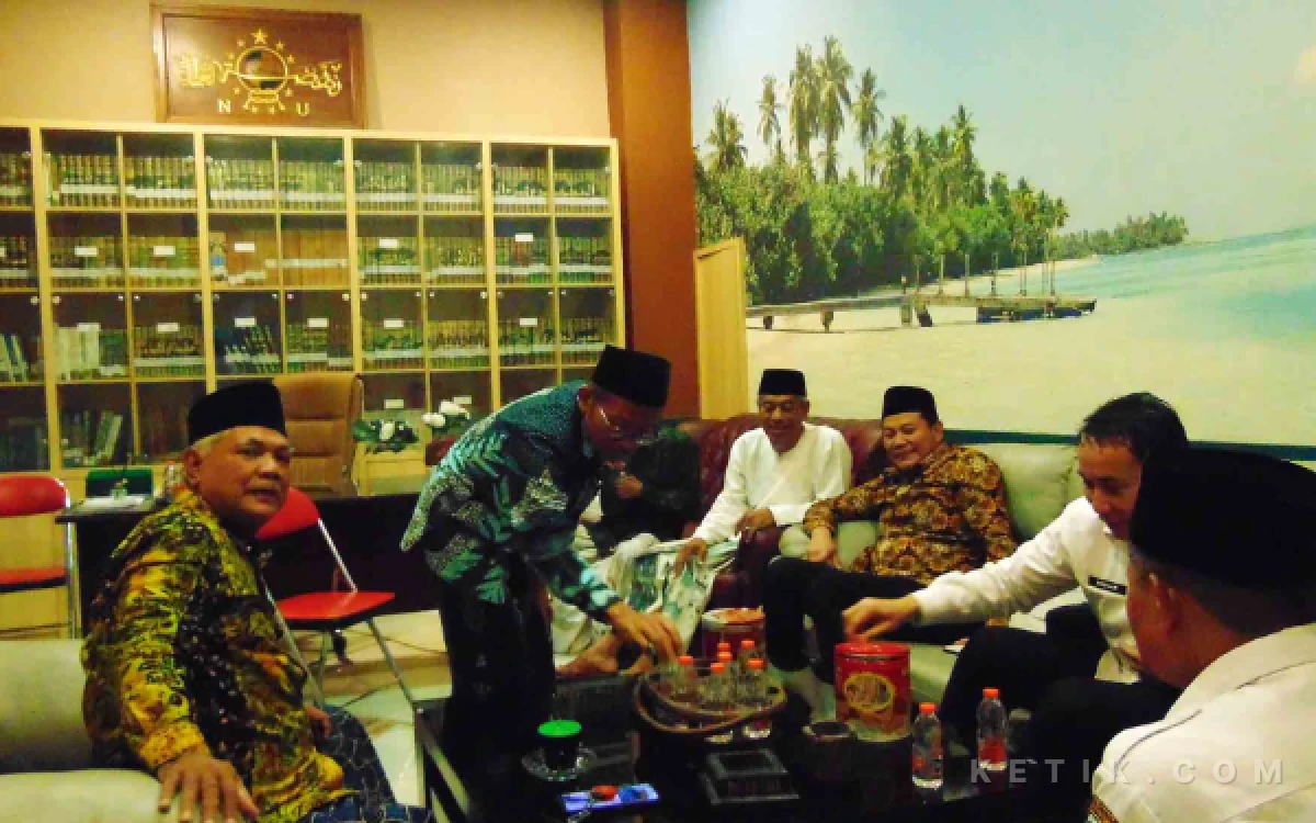 Foto Ketua PCNU Sidoarjo KH Zainal Abidin menyuguhan kopi untuk Bupati Subandi dan Kepala Inspektorat Kabupaten Sidoarjo Andjar Surjadianto didampingi pengurus NU lainnya.  (Foto: Fathur Roziq/Ketik.com)