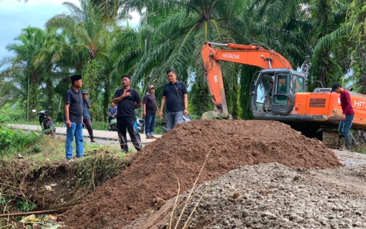 Foto Anggota DPRK Abdya, Zulkarnaini (memakai peci) meninjau perbaikan jalan penghubung Desa Pantai Cermin dan Desa Cot Seumantok di Babahrot yang rusak akibat banjir yang dikerjakan PT Kenpura dan PT BBR, Jumat (14/8/2026). (Foto: T. Rahmat/Ketik)