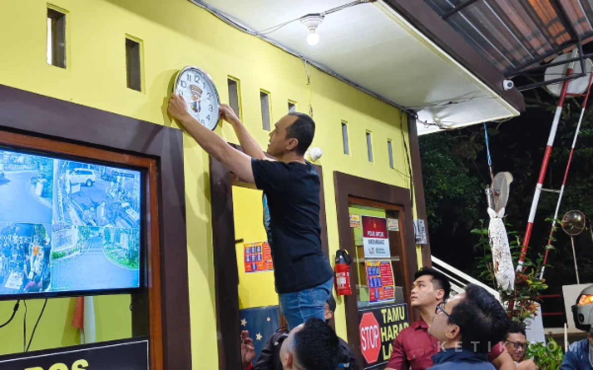 Foto Aksi Kapolresta Malang Kota,  Kombes Pol Putu Kholis Aryana, saat memasang jam di dinding Poskamling RT 01/RW 07 Kelurahan Cemorokandang, Kecamatan Kedungkandang, Kota Malang, Sabtu, 30 Mei 2026. (Foto: Dendy/Ketik.com)