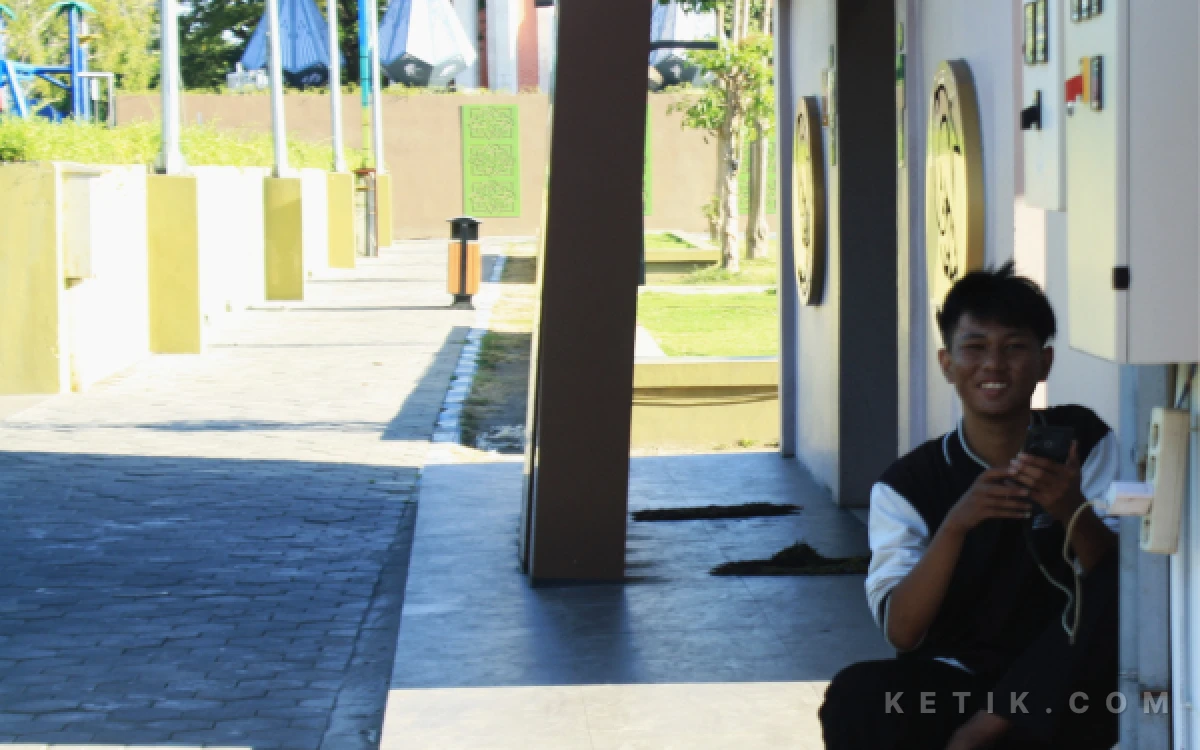 Foto Seorang pengunjung mojok sendirian sambil menikmati internet dan listrik gratis di Alun-Alun Sidoarjo.  (Foto: Fathur Roziq/Ketik.com)