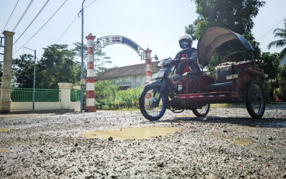 Foto Jalan Prof. Dr. Moestopo di wilayah Desa Mentoro, Kecamatan Pacitan, Kamis (11/6/2026) usai disirami oleh warga setempat untuk mengurangi dampak debu. Kerusakan jalan yang disebut telah berlangsung tahunan itu menimbulkan debu tebal dan dikeluhkan warga karena berdampak pada kesehatan, ekonomi, serta keselamatan pengguna jalan.